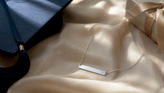 Personalized silver graduation necklace on linen