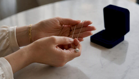Mujer sosteniendo un collar con dije de diamante