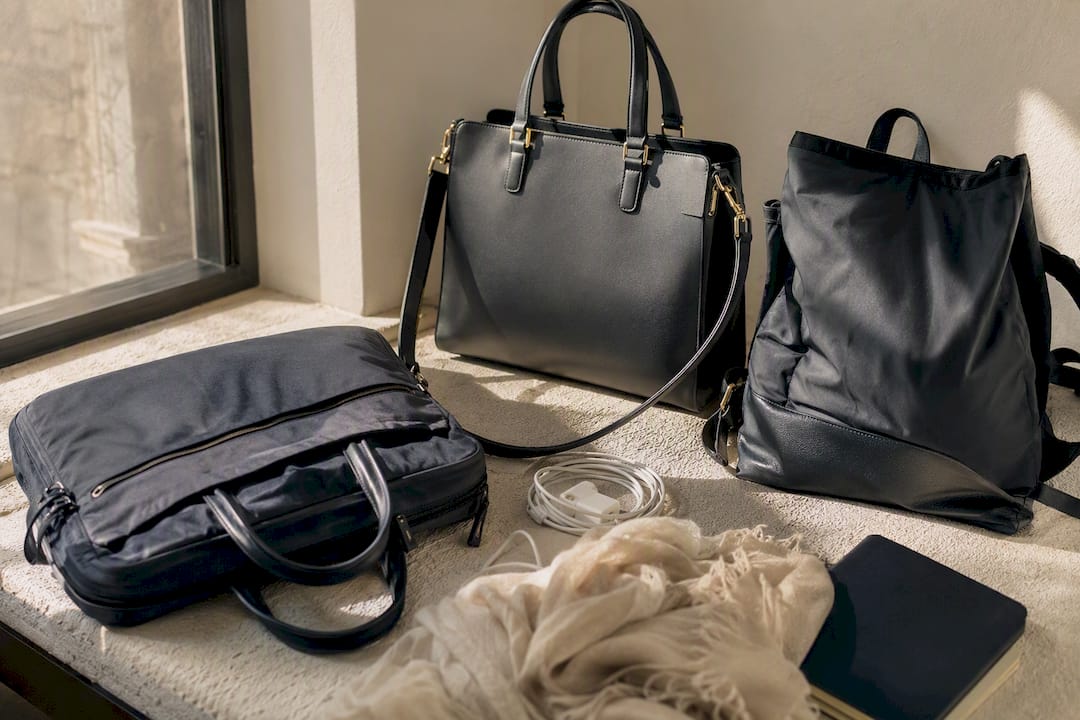 Three work handbag styles on a textured surface