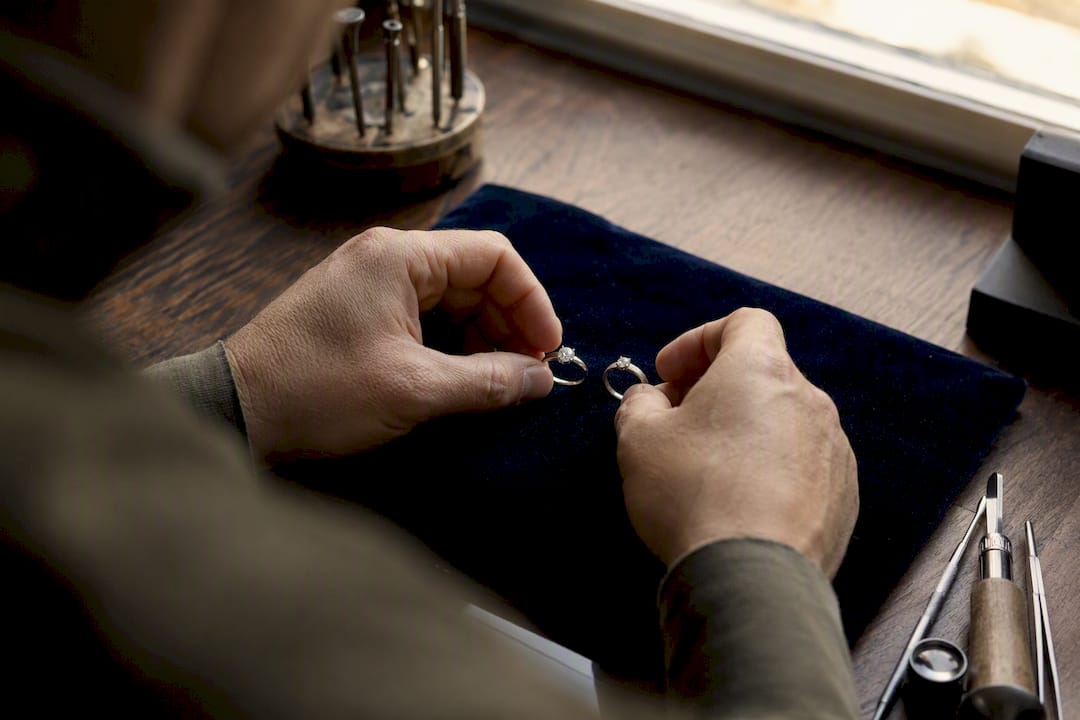 Close-up of hands holding platinum and white gold rings