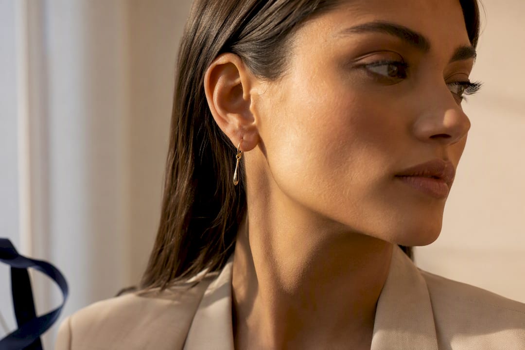 Profile model wearing an anonymous drop earring