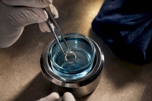 Jeweler applying rhodium plating to metal setting