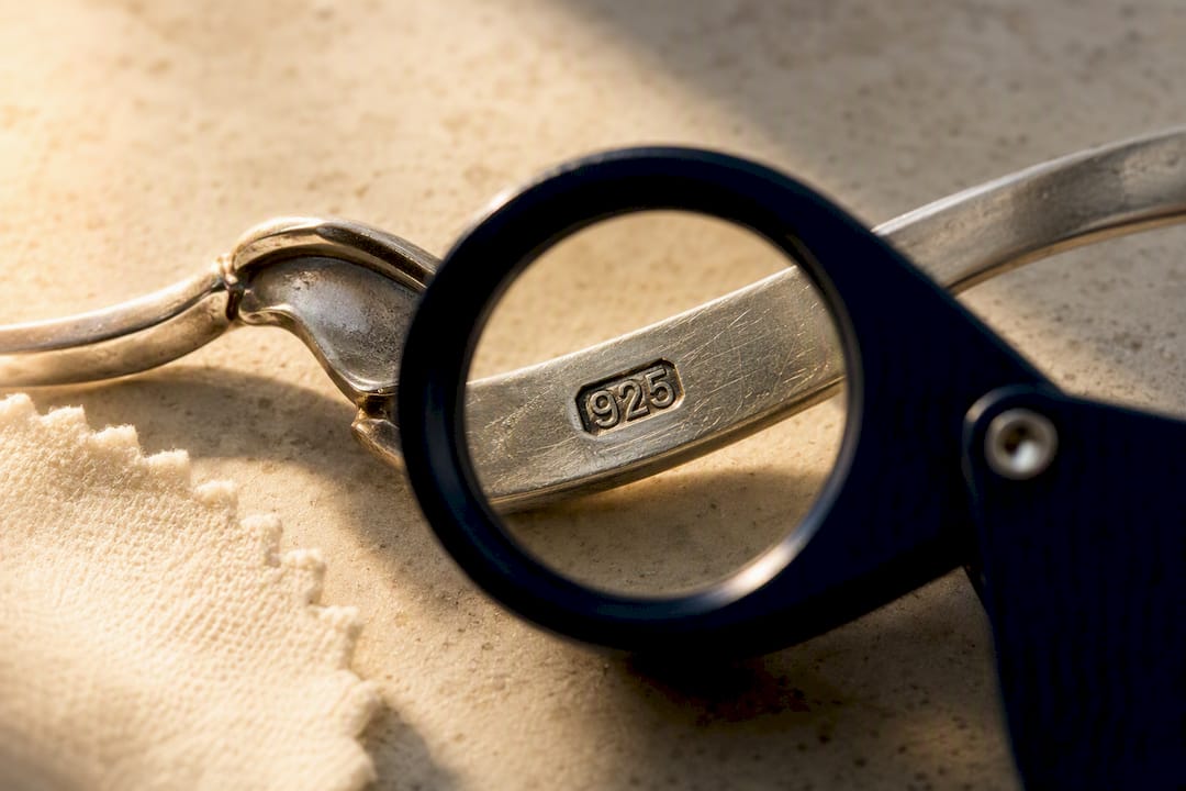 Loupe examining a silver hallmark