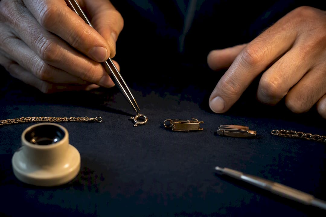 Jeweler inspecting anonymous clasp mechanisms